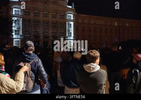 Una grande folla osserva proiezioni di luce bianca intricate trasformare la facciata di un edificio storico durante il Signal Festival 2026. Foto Stock