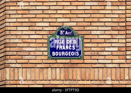 Targa del nome della strada Rue des Francs Bourgeois blu e verde che segna il 3° arrondissement, montata su un muro di mattoni nel quartiere Le Marais. Foto Stock
