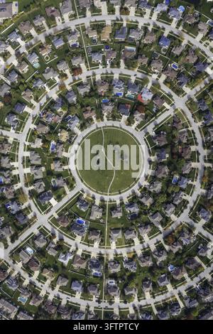 Vista aerea di un quartiere suburbano circolare con case disposte in anelli concentrici attorno a un parco verde centrale nell'Illinois, Stati Uniti. Foto Stock