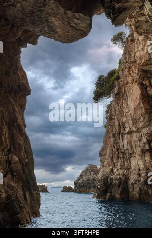 Fotografia del paesaggio in grandangolo verticale che guarda fuori dall'arco interno della Grotta Blu (Plava Špilja) sull'isola di Koločep in Croazia. Foto Stock