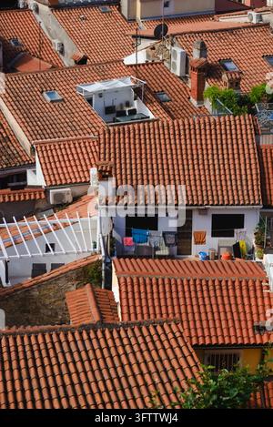Vista elevata di dense tegole di terracotta e balconi nella storica città costiera di Piran, in Slovenia. Foto Stock