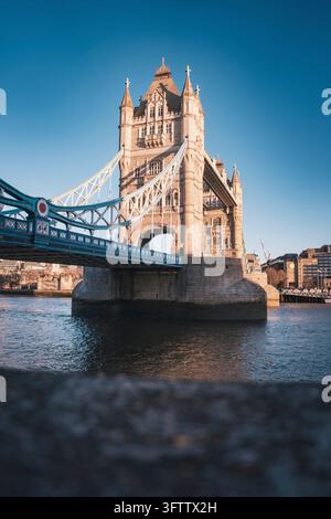 Il Tower Bridge illuminato dal sole attraversa il Tamigi davanti a un cielo blu chiaro, Londra, Regno Unito Foto Stock