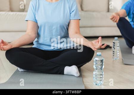 Meditazione sulla consapevolezza dello yoga. Coppia matura senior che pratica yoga a casa. Mani nel mento mudra gesto. Il vecchio marito moglie seduto in posa di loto meditando rilassandosi. Famiglia che pratica la respirazione. Foto Stock