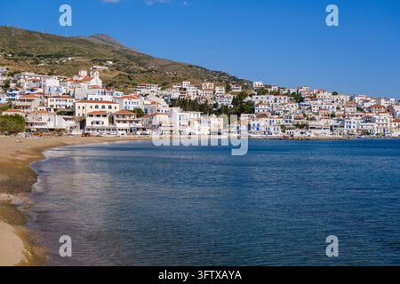 Andros, Grecia - 21 maggio 2026: Villaggio di Batsi con edifici sul lungomare e spiaggia sull'isola di Andros Foto Stock