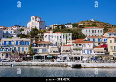 Andros, Grecia - 21 maggio 2026: Villaggio di Batsi con edifici sul lungomare e spiaggia sull'isola di Andros Foto Stock