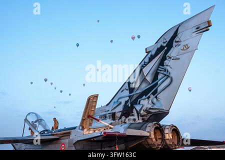 *Uso editoriale solo* - San Damiano, Piacenza, Italia. 17 ott., 2026. Un jet da combattimento Tornado è raffigurato in primo piano mentre i palloni ad aria calda decollano durante una competizione di palloni ad aria calda al mattino presto alla 3a edizione dell'Aeronautica Militare Balloon Cup alla base aerea di San Damiano. Credit: Claudio Rancati/Alamy Live News Foto Stock