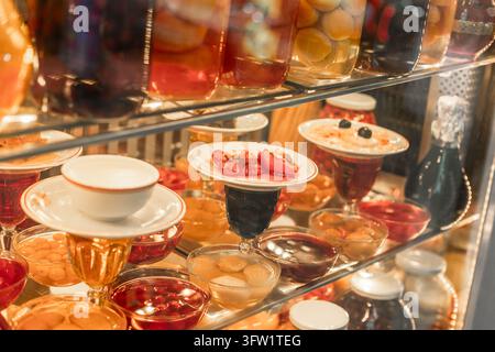 Turchia, Istanbul 2025 10 03: Vari dessert turchi tradizionali, conserve e marmellate di frutta esposti ordinatamente su scaffali di vetro in un ambiente illuminato Foto Stock
