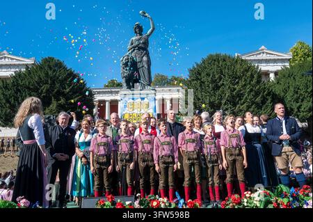 Muenchen., Oktoberfest, Wiesnwirte Platzkonzert sui gradini sotto la Bavaria, il Bayer- e il Deutschlandlied cantati dai Regensburger Domspatzen con Wiesn Wirtinnen e Wiorten *** Monaco di Baviera, Oktoberfest, concerto all'aperto dei locandieri della Wiesn sui gradini sotto la statua della Bavaria, con il Bayer e il Deutschlandlied cantati dai Regensburger Domspatzen insieme alle locandiere e locandieri della Wiesn Foto Stock