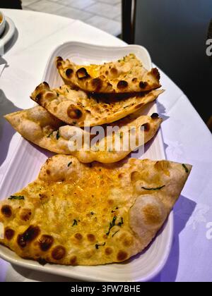 Piatto di naan all'aglio, o pane naan, in un ristorante indiano nel Sussex, UK Foto Stock