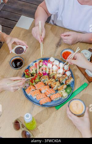 Gruppo di persone che condividono un grande vassoio di sushi in un ristorante Foto Stock