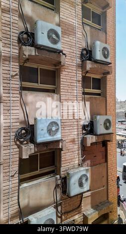 La Mecca, Arabia Saudita – 12 marzo 2024: Unità di climatizzazione esterne montate sulla parete in mattoni esterna di un edificio alberghiero Foto Stock
