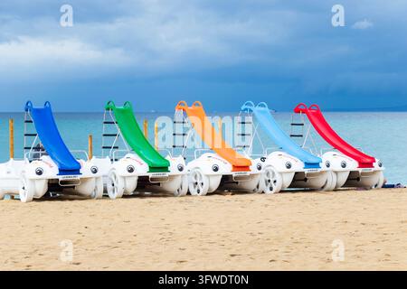 Pedalo di La Noria con scivoli d'acqua allineati sulla sabbia vicino al mare a C'an Pastilla, Mallorca, Spagna Foto Stock