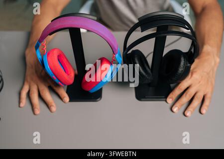 Vista ad angolo alto di due diverse opzioni di cuffie. Concetto di scelta, confronto, recensione. Per gaming, streaming, musica, podcasting. Equi audio moderno Foto Stock
