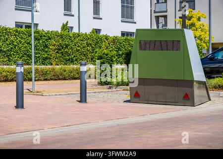 Telecamera mobile per il controllo della velocità su una strada urbana accanto ad appartamenti e veicoli parcheggiati Foto Stock