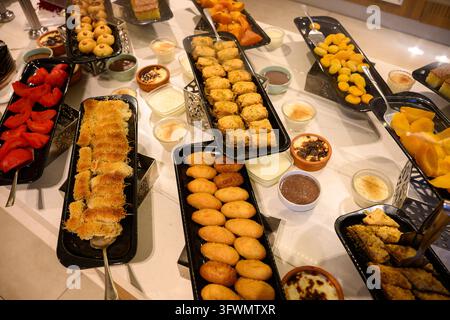 Dolci e pasticcini turchi tradizionali su un buffet di lusso in hotel, primo piano. Dolce kunefe, kadaif, budino di riso sutlac e baklava su piatti. Orientale c Foto Stock