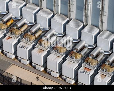Sistemi di ventilazione di raffreddamento esterni installati a file in una struttura di data center aiutano a regolare la temperatura per i grandi server durante il giorno Foto Stock