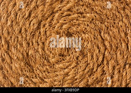 Superficie di tappeto in fibra di cocco marrone tessuta a tutto campo. Corda di fibra di cocco grossa e ritorta e motivo di tessitura in iuta naturale ruvida in vista dall'alto e primo piano macro. Foto Stock