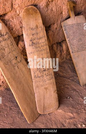 PanneLLI di legno con scrittura araba appoggiati a un muro di fango in una scuola coranica, regione del Sahel, Bani, Burkina Faso Foto Stock