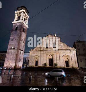 TORINO, ITALIA - 21 OTTOBRE 2026 - Il duomo di Torino e il suo campanile che brillano su strade bagnate, con un'auto che passa di notte Foto Stock