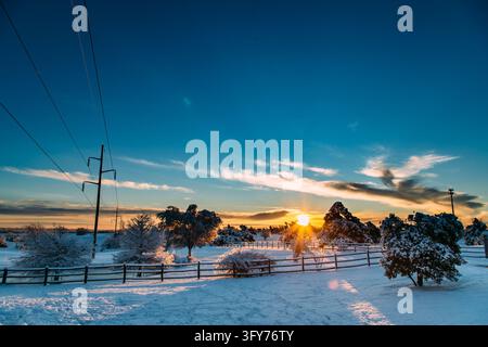 Alba dorata su un paesaggio rurale innevato Foto Stock