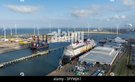 Vista aerea del porto industriale di Eemshaven con turbine eoliche, una grande nave da crociera ormeggiata al molo e container di merci a Eemshaven Foto Stock