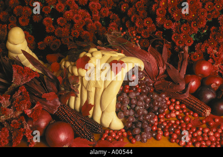 Bagliore rosso: fatto a mano cornucopia centrotavola fatta di pane traboccante di viola e frutti rossi e fiori per Harvest Dinner, STATI UNITI D'AMERICA Foto Stock