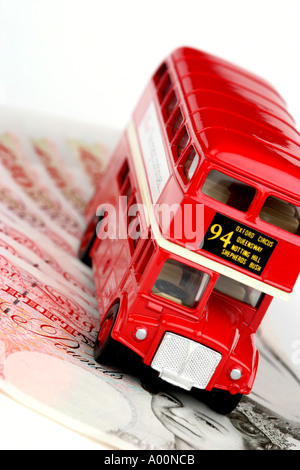 Red London bus su un mucchio di soldi Foto Stock