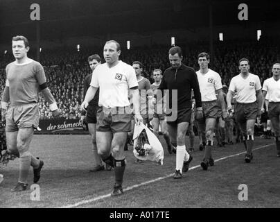 Calcio, Bundesliga, 1965/1966, FC Schalke 04 contro Hamburger SV 2:1, Stadio Glueckauf Kampfbahn, entrambe le squadre entrano nello stadio, capitano della squadra, capitani Manfred Kreuz e Uwe Seeler, b&W, bianco e nero, la fotografia in bianco e nero Foto Stock