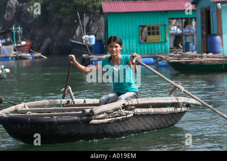 Cappello conico righe donna tessuto tradizionale in barca attorno a floating villaggio di pescatori Cat Ba Town Bay a nord-est del Vietnam Foto Stock