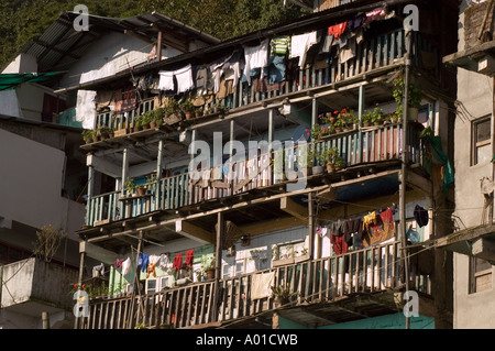 Asciugatura dei vestiti sul balcone dell'edificio di appartamenti a Darjeeling nel Bengala Occidentale, India. Tradizionale architettura collinare con lavanderia e piante in vaso. Foto Stock