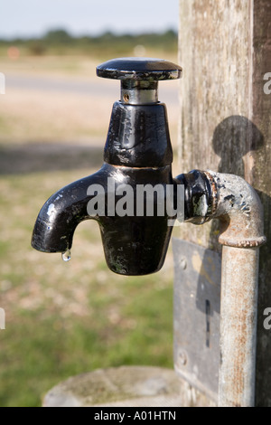 Supporto nero tubo tocca pubblica di gocciolamento di acqua Foto Stock