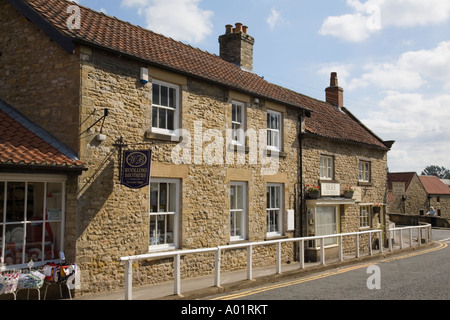 Sabbia tradizionale cottage in pietra negozi nel pittoresco villaggio Helmsley Yorkshire England Regno Unito Foto Stock