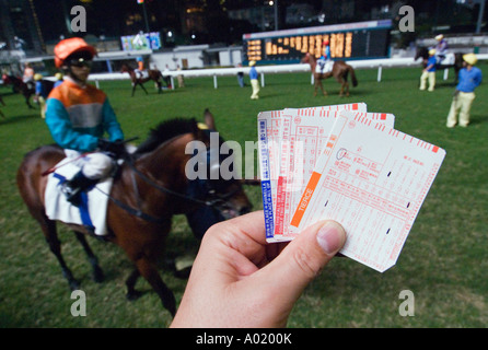 Uomo con coupon di scommesse all Ippodromo Happy Valley Hong Kong Foto Stock