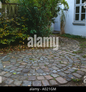 Circolare di pietre per pavimentazione in piccolo cortile Foto Stock
