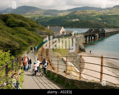 La gente a piedi il sentiero mawddach percorso a Blaenau Ffestiniog, Gwynedd Galles del Nord, pomeriggio estivo Wales UK, ponte ferroviario in background Foto Stock