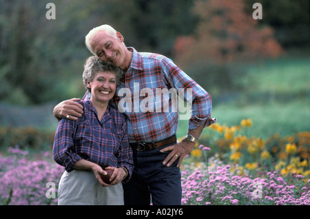 Felice coppia in pensione nel loro cortile anteriore Foto Stock