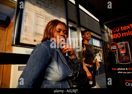 Donne che aspettano alla fermata dell'autobus a North London Foto Stock