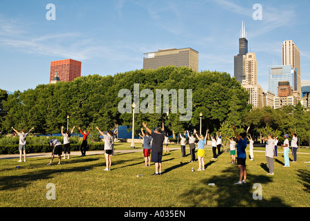 ILLINOIS Chicago esercizio di gruppo classe in mattina presto Grant Park Sears Tower e dello skyline della città Foto Stock