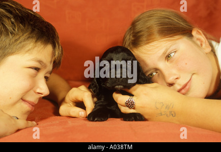 Un ragazzo e una ragazza cuddling loro cucciolo Foto Stock