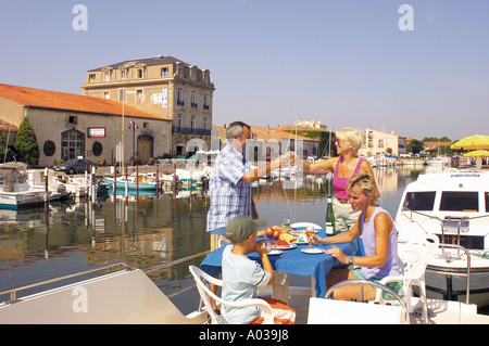 PICNIC IN FAMIGLIA SUL PONTE DI UNA NAVE IN PORTO MARSEILLAN, IL SUD DELLA FRANCIA. Foto Stock