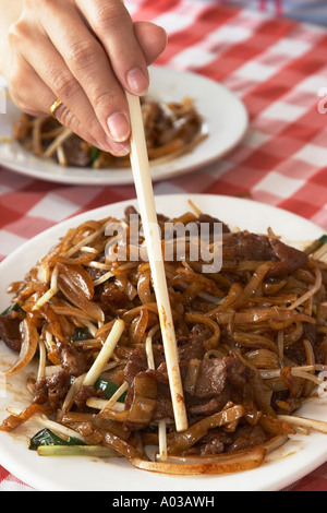 Bacchette essendo utilizzato da donna, Hong Kong Foto Stock