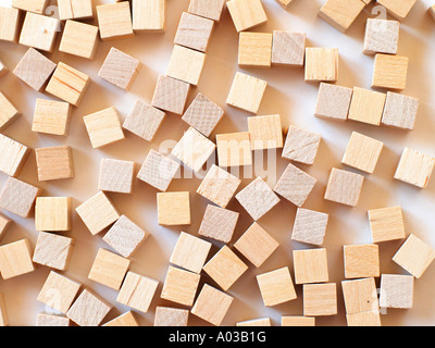 Molti piccoli cubi di legno sparsi in una superficie bianca. Foto Stock