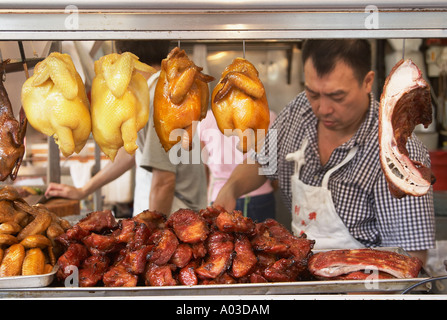 L'uomo tagliando la carne in negozio, Hong Kong Foto Stock