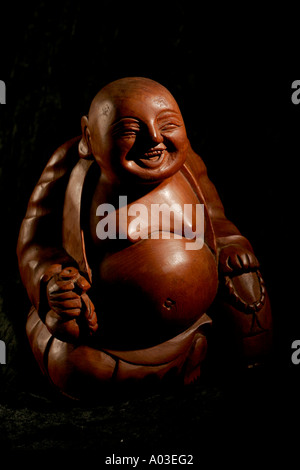 Un Buddha Sorridente fatta a mano in legno in Thailandia Foto Stock