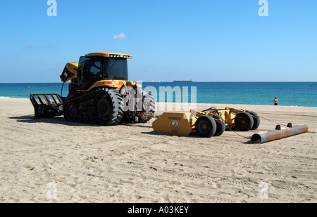 Spiaggia di manutenzione pulizia del trattore litorale Fort Lauderdale Florida USA un gatto trattore tirando una sabbia di Reynolds rastrello Foto Stock