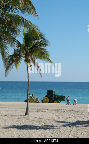 Spiaggia di manutenzione pulizia del trattore litorale Fort Lauderdale Florida usa un trattore John Deere tirando un barbiere rake surf Foto Stock