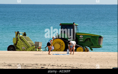 Spiaggia di manutenzione pulizia del trattore litorale Fort Lauderdale Florida usa un trattore John Deere tirando un barbiere rake surf Foto Stock