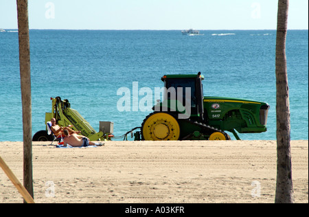 Spiaggia di manutenzione pulizia del trattore litorale Fort Lauderdale Florida usa un trattore John Deere tirando un barbiere rake surf Foto Stock