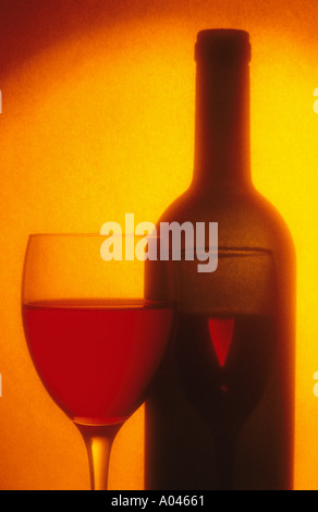 Un bicchiere di vino e bottiglia di vino toni caldi Foto Stock