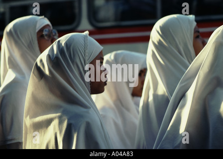 Studentesse musulmane in attesa di un autobus a Singapore Foto Stock